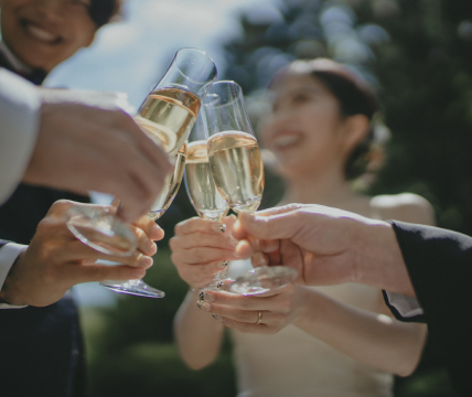 写真：新郎新婦やお客様がみんなでシャンパングラスを持って乾杯する様子