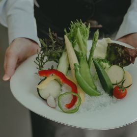 写真：色とりどりの野菜が盛られたお皿をもっているスタッフの手元