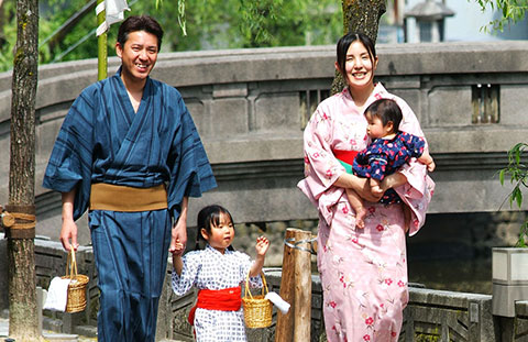写真：浴衣を着たご家族が城崎の街を歩いている様子